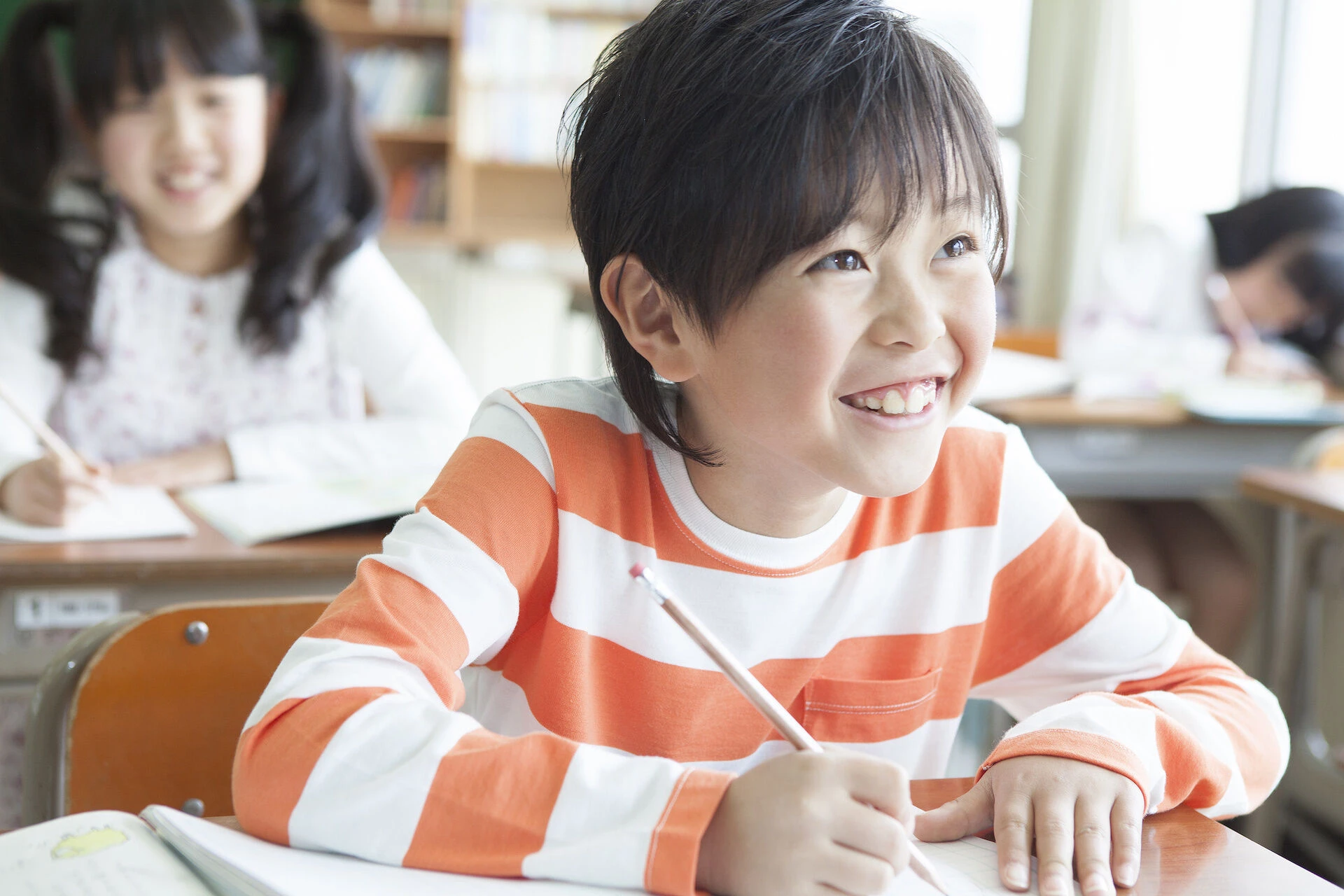 タブレットを使って目を輝かせながら学ぶ小学生