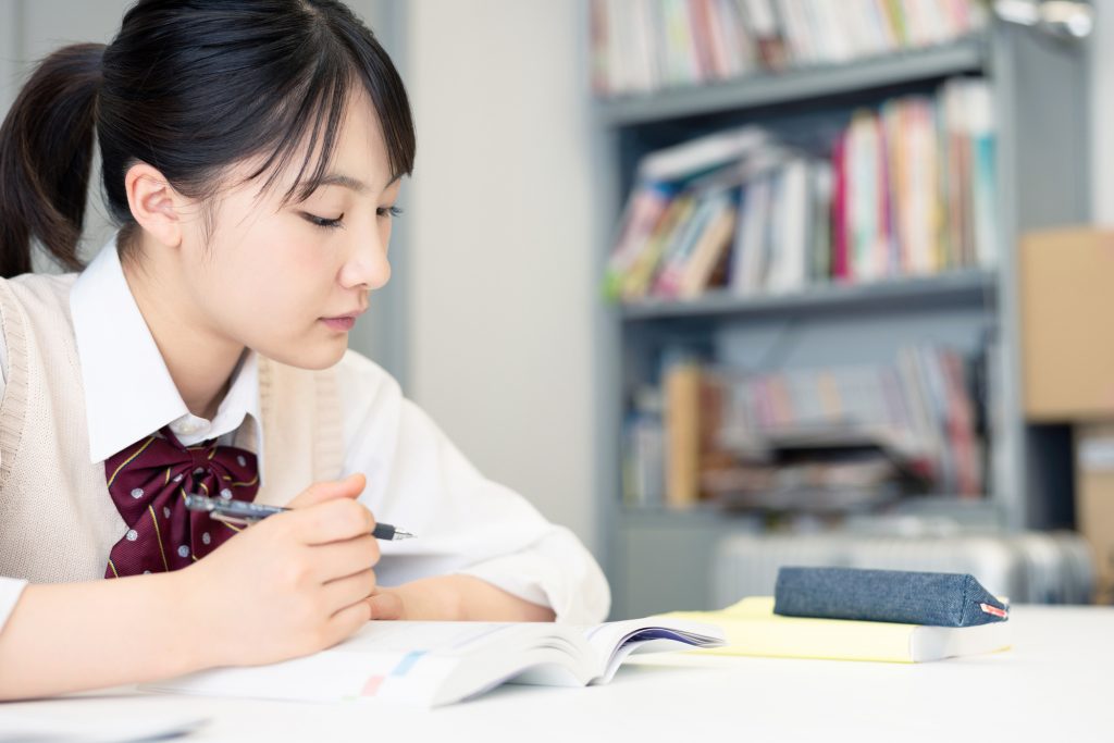 自習室で集中して課題に取り組む高校生
